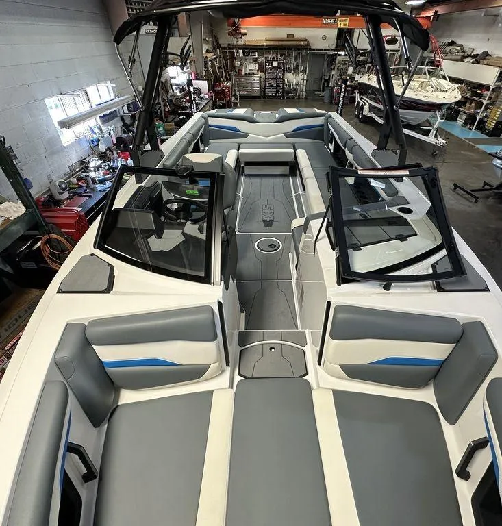 Slide: The Image of 2024 Axis T250 boat interior with gray and blue seating in a workshop setting. - 10