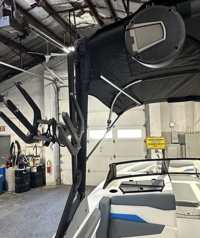 Slide: The Image of 2024 Axis T250 boat interior with speaker and wakeboard rack in a garage. - 17