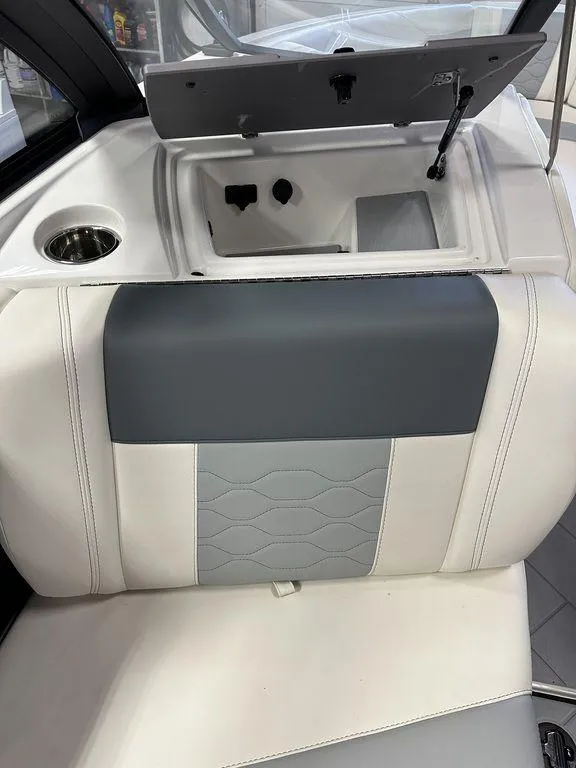 Slide: The Image of 2024 Malibu 23 LSV boat interior with gray and white seating and storage compartment. - 13