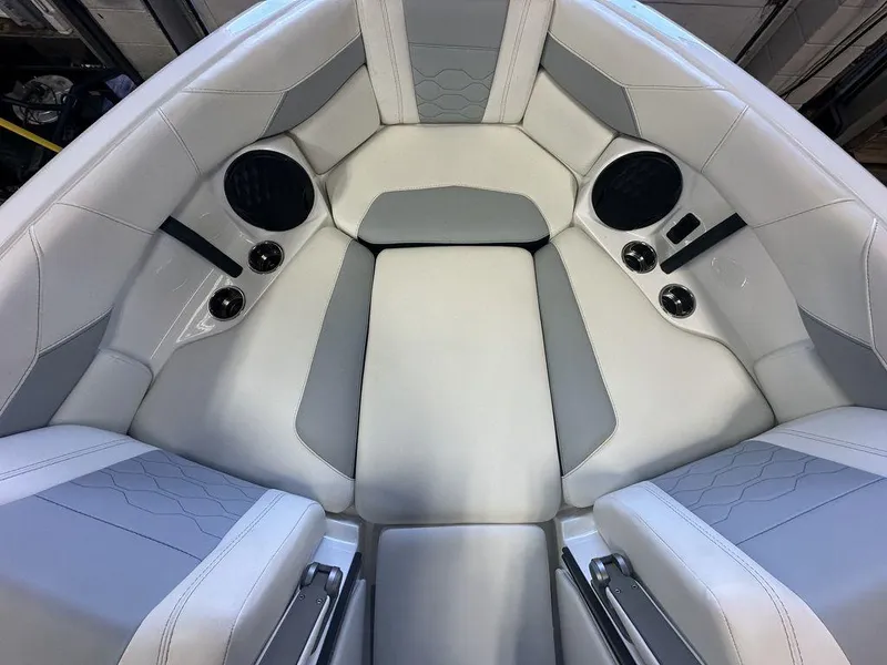 Slide: The Image of 2024 Malibu 23 LSV boat interior with white and gray seating and built-in speakers. - 19