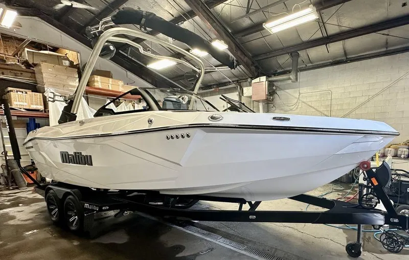 Slide: The Image of 2024 Malibu 23 LSV boat in a warehouse, on a trailer, side view. - 4