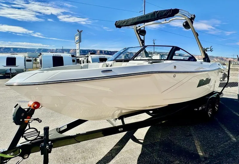 Slide: The Image of 2024 Malibu 23 LSV boat on trailer, sleek design, sunny day. - 5