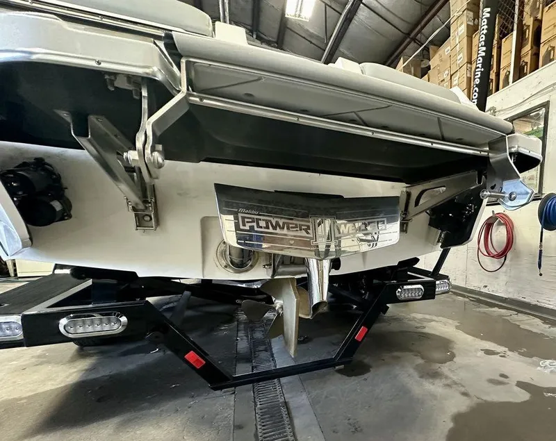 Slide: The Image of 2024 Malibu 23 LSV boat rear view in a garage setting. - 8