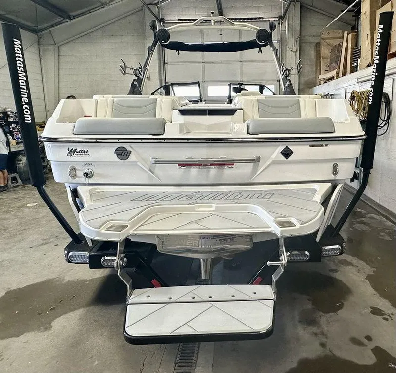 Slide: The Image of 2024 Malibu 23 LSV boat in a garage, rear view with swim platform. - 9