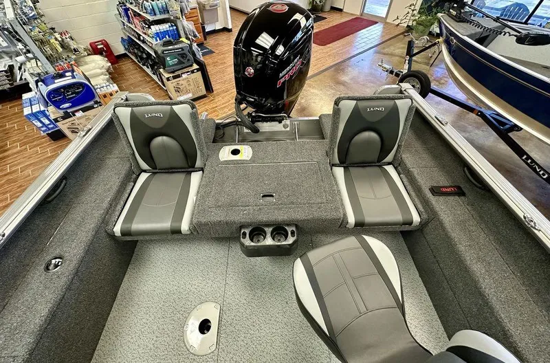 Slide: The Image of 2024 Lund 1775 Impact XS Sport boat interior with seating and motor. - 3
