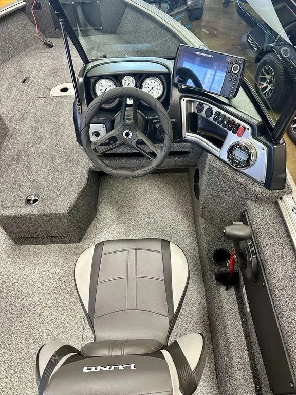 Slide: The Image of 2024 Lund 1775 Impact XS Sport boat cockpit with steering wheel and control panel. - 7