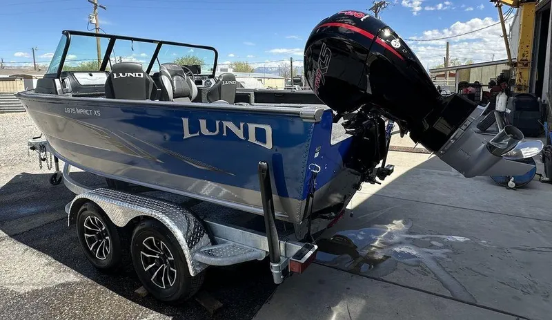 Slide: The Image of 2024 Lund 1875 Impact XS Sport boat on trailer with outboard motor. - 4