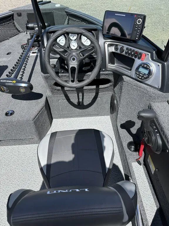 Slide: The Image of 2024 Lund 1875 Impact XS Sport boat cockpit with steering wheel and control panel. - 6