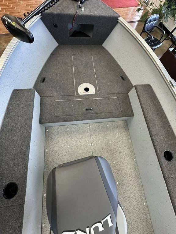 Slide: The Image of 2024 Lund 1400 Fury Tiller boat interior with gray carpet and seating. - 6