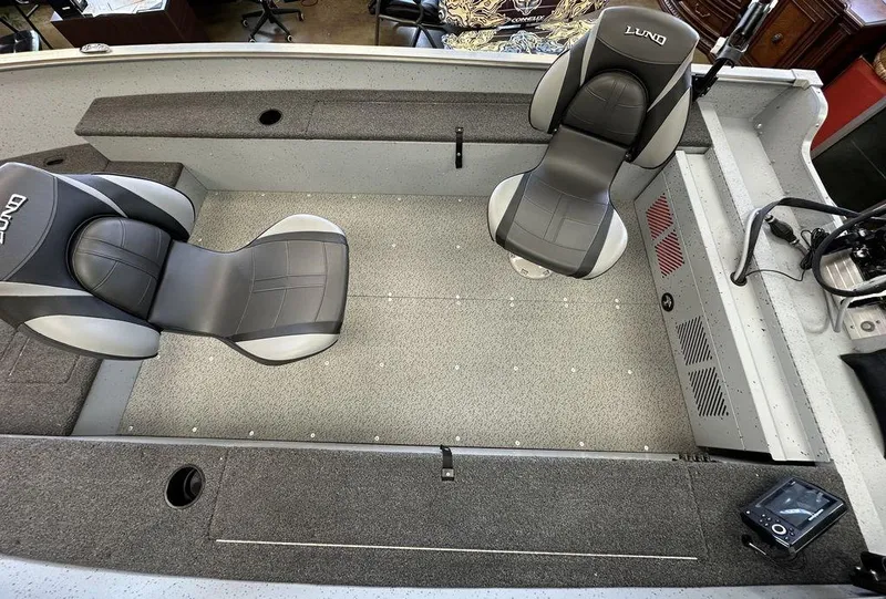 Slide: The Image of 2024 Lund 1400 Fury Tiller boat interior with two seats and storage compartments. - 7