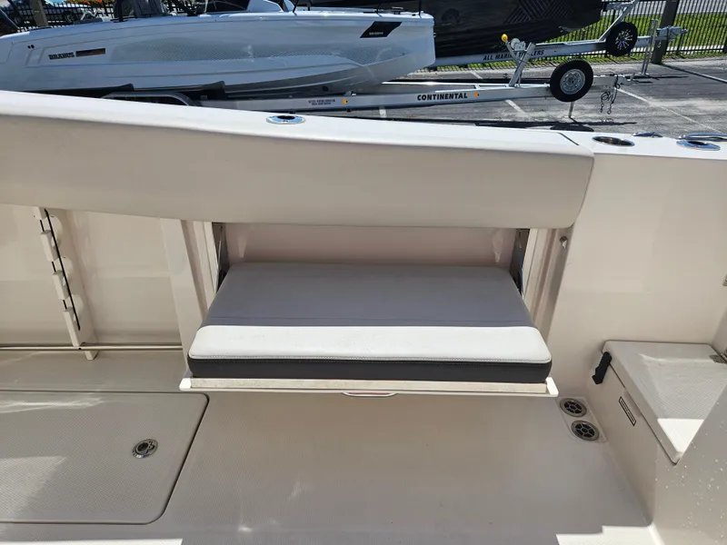 Slide: The Image of 2024 Sailfish 312CC boat with fold-down seat and storage compartment. - 12