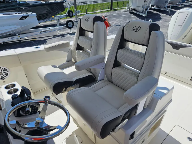 Slide: The Image of 2024 Sailfish 312CC boat cockpit with dual captain's chairs and steering wheel. - 21