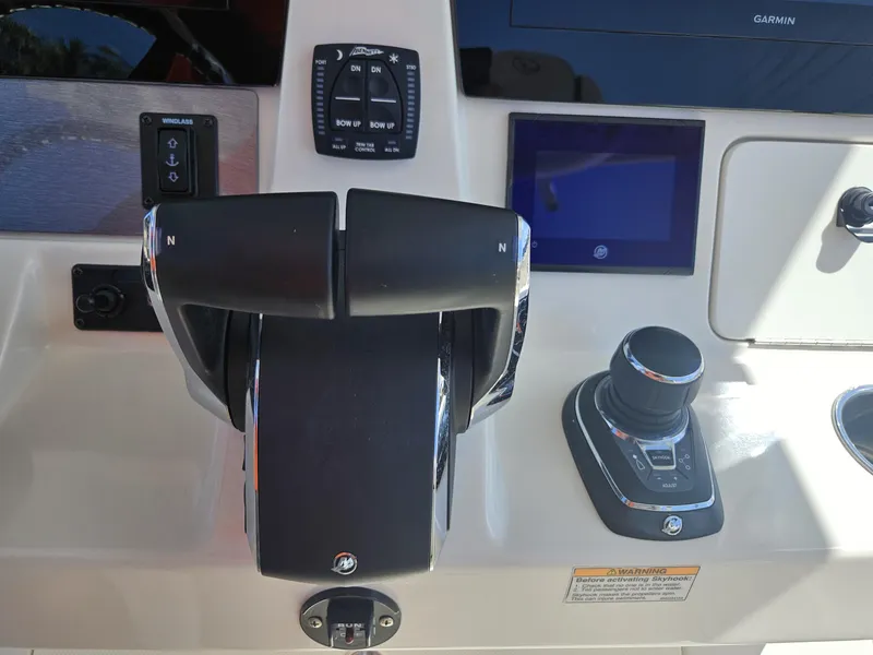 Slide: The Image of 2024 Sailfish 312CC boat control panel with throttle and joystick. - 28