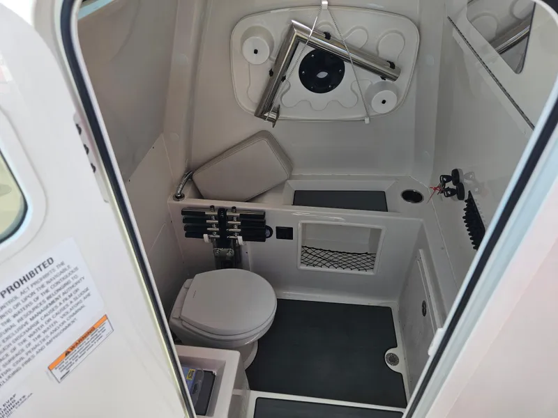 Slide: The Image of 2024 Sailfish 312CC boat interior bathroom with toilet and storage compartments. - 31