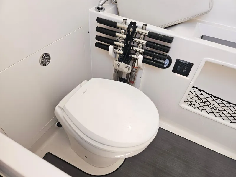 Slide: The Image of 2024 Sailfish 312CC boat interior with toilet and rod holders. - 33