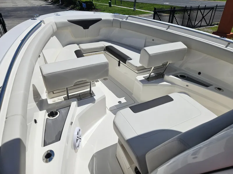 Slide: The Image of 2024 Sailfish 312CC boat interior with white cushioned seating and cup holders. - 36