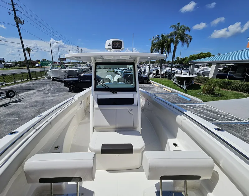 Slide: The Image of 2024 Sailfish 312CC boat interior with seating and console, docked at a marina. - 42