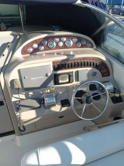 Slide: The Image of 2001 Sea Ray 290 Amberjack boat dashboard with steering wheel and navigation controls. - 6