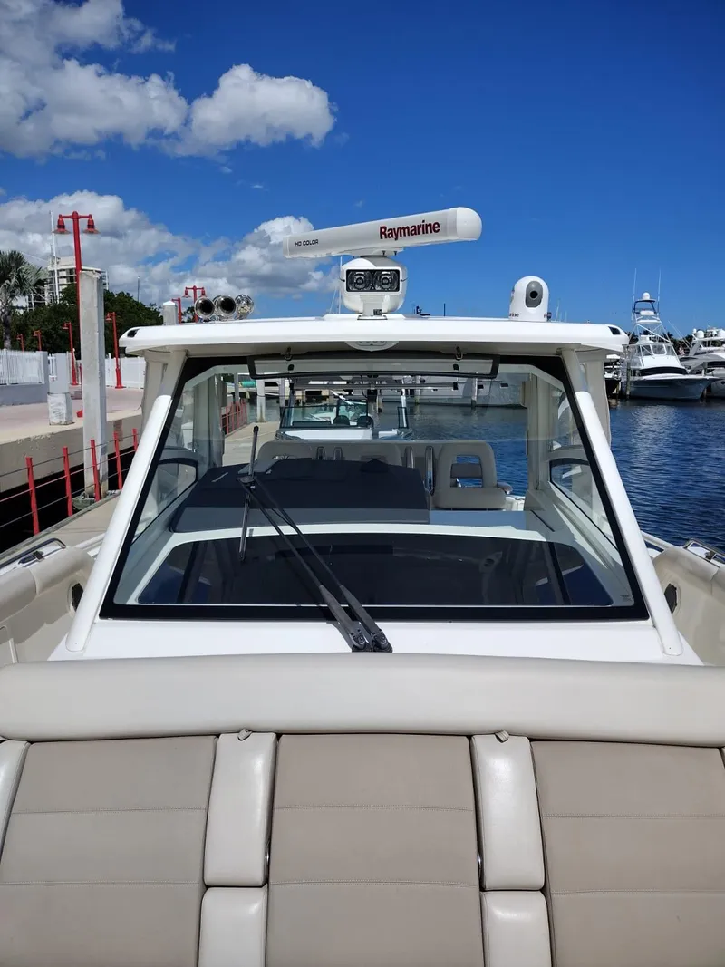Slide: The Image of 2018 Boston Whaler 420 Outrage docked, featuring sleek design and advanced navigation equipment. - 11