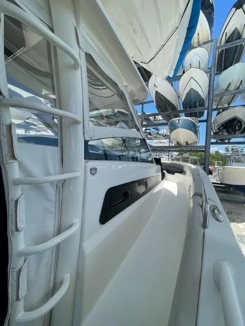 Slide: The Image of 2018 Boston Whaler 420 Outrage boat docked, surrounded by other vessels. - 16