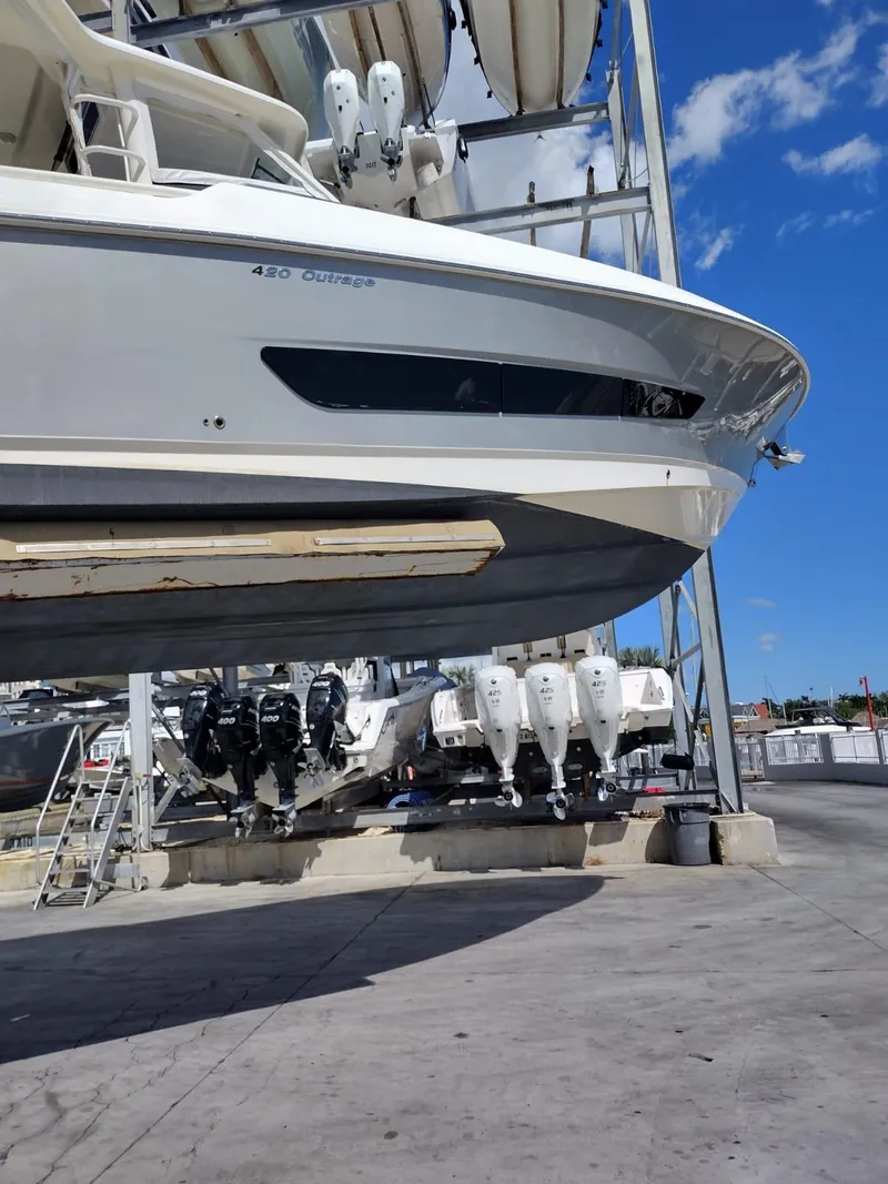 Slide: The Image of 2018 Boston Whaler 420 Outrage boat in dry dock, showcasing sleek design and powerful engines. - 28