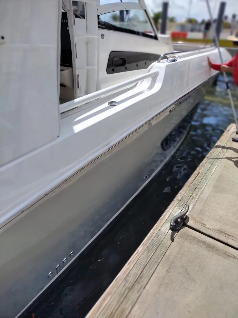 Slide: The Image of 2018 Boston Whaler 420 Outrage docked, showcasing sleek white hull and modern design. - 33