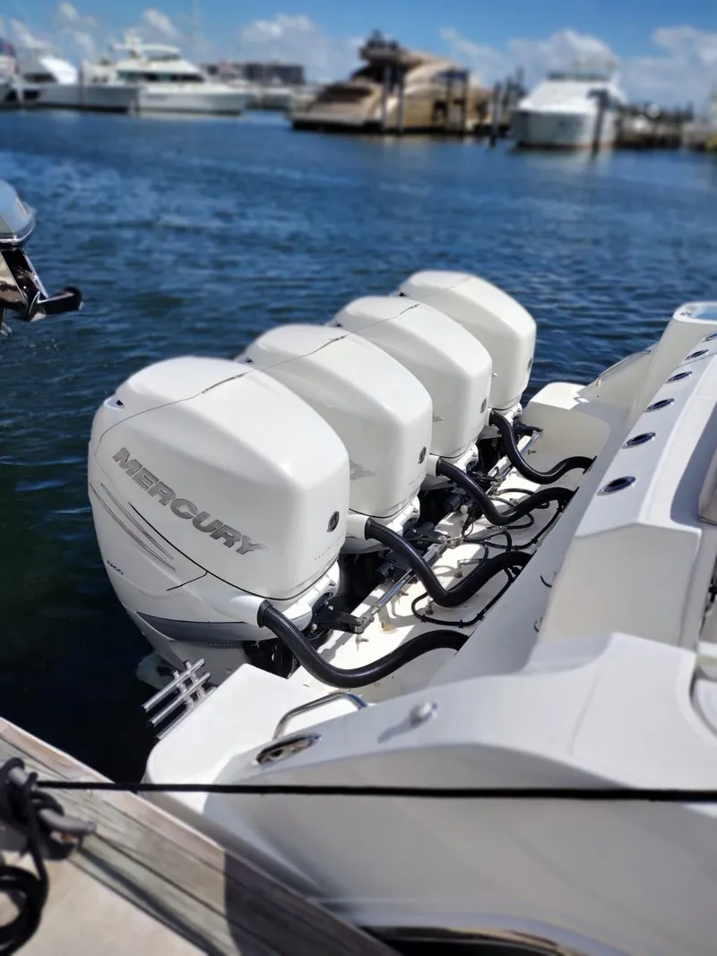 Slide: The Image of Four Mercury outboard engines on a 2018 Boston Whaler 420 Outrage, docked at a marina. - 38