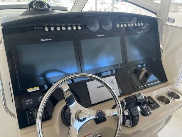 Slide: The Image of Control panel of a 2018 Boston Whaler 420 Outrage with multiple screens and steering wheel. - 41