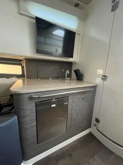 Slide: The Image of 2018 Boston Whaler 420 Outrage interior with kitchenette, TV, and modern cabinetry. - 45