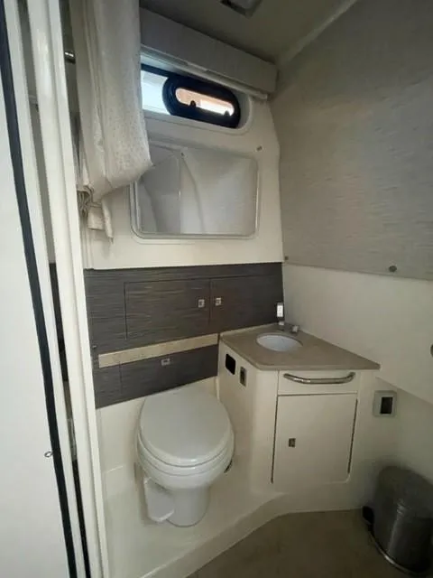 Slide: The Image of 2018 Boston Whaler 420 Outrage bathroom with toilet, sink, and window. - 49