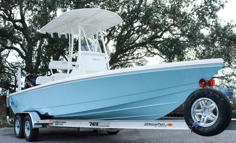 The Image of 2024 Pathfinder 2300 HPS boat on trailer, light blue hull, white T-top, parked outdoors. - 0