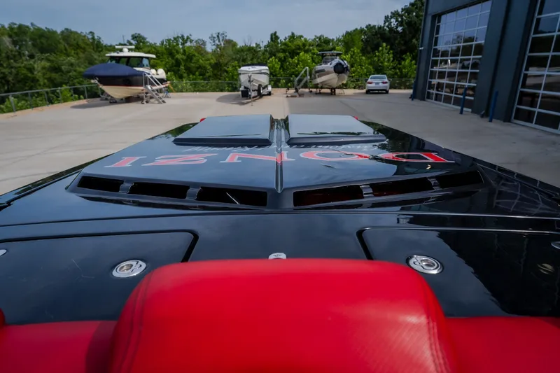 Slide: The Image of 2009 Donzi 38 ZRC speedboat with sleek black design and red accents, parked near other boats. - 35
