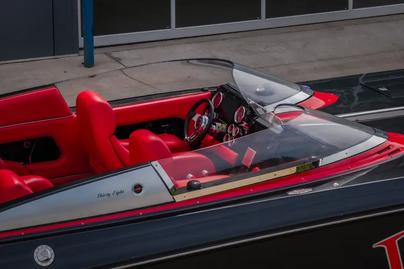 Slide: The Image of 2009 Donzi 38 ZRC speedboat with vibrant red interior and sleek dashboard design. - 15