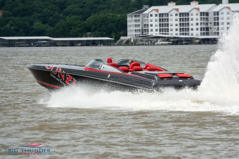 Slide: The Image of 2009 Donzi 38 ZRC speedboat on water near waterfront buildings. - 2