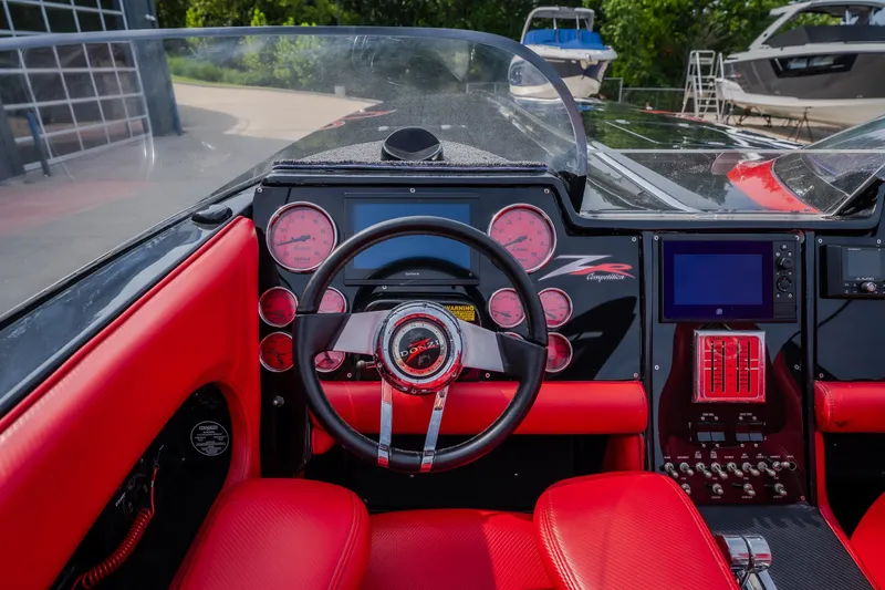 Slide: The Image of Interior of a 2009 Donzi 38 ZRC boat with red and black dashboard. - 47