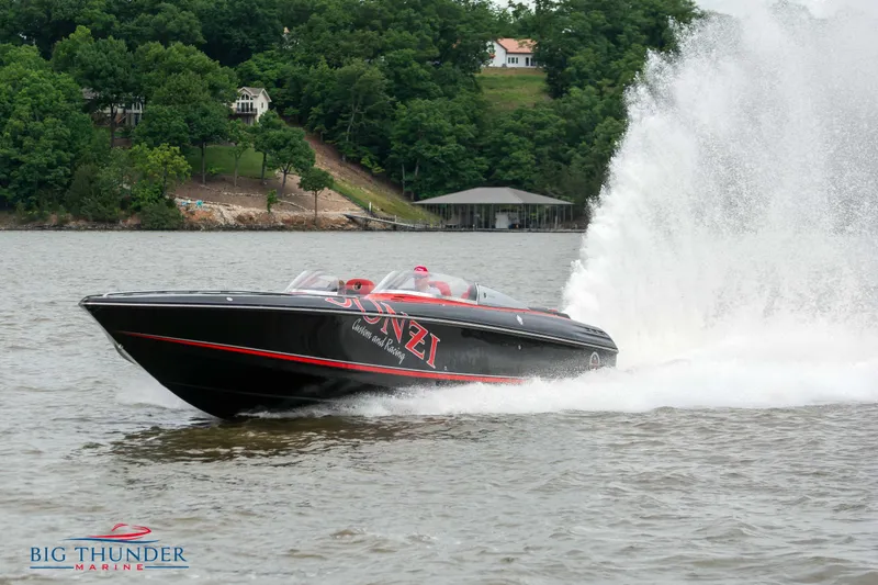 Slide: The Image of 2009 Donzi 38 ZRC speedboat cruising on a lake with water spray. - 3