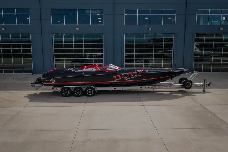 Slide: The Image of 2009 Donzi 38 ZRC speedboat on trailer, parked outside modern building. - 52