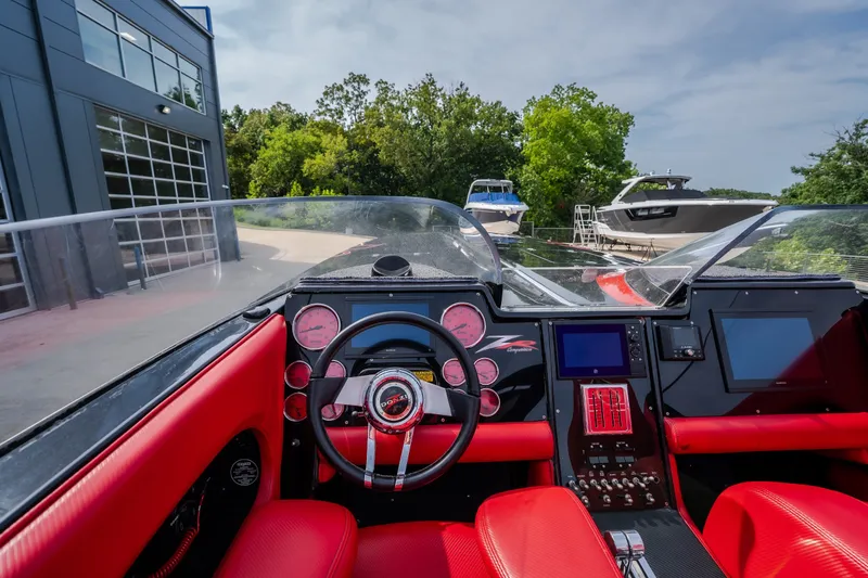 Slide: The Image of Interior view of a 2009 Donzi 38 ZRC speedboat with red seating and modern dashboard. - 48