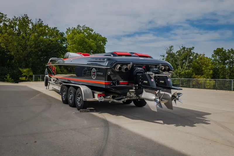 Slide: The Image of 2009 Donzi 38 ZRC speedboat on trailer, parked outdoors, showcasing powerful engines. - 32