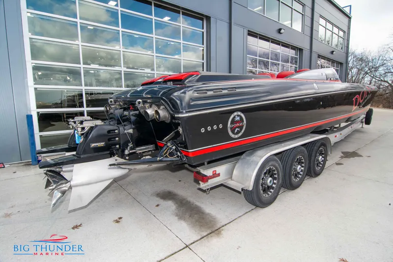 Slide: The Image of 2009 Donzi 38 ZRC powerboat on a trailer outside a marine dealership. - 9