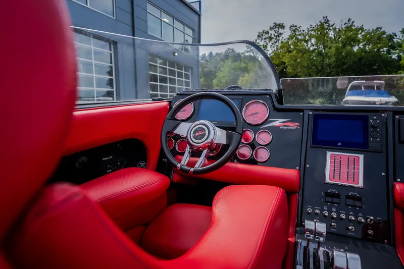 Slide: The Image of Interior of a 2009 Donzi 38 ZRC boat with red leather seats and modern dashboard. - 38
