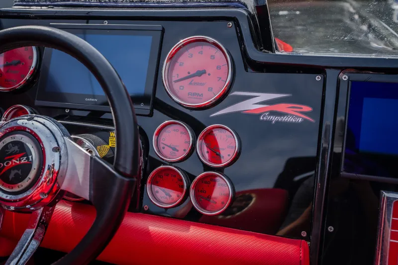 Slide: The Image of Dashboard of a 2009 Donzi 38 ZRC boat with red gauges and steering wheel. - 31