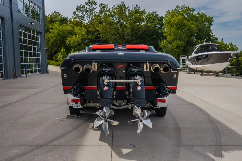 Slide: The Image of 2009 Donzi 38 ZRC speedboat with dual propellers, parked outdoors near a modern building. - 17