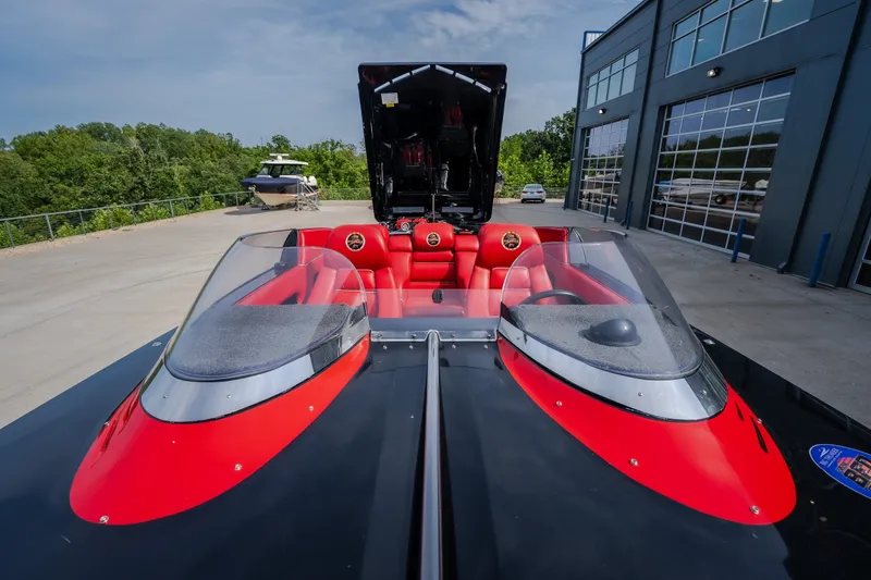 Slide: The Image of 2009 Donzi 38 ZRC speedboat with red and black interior, parked near a modern building. - 50