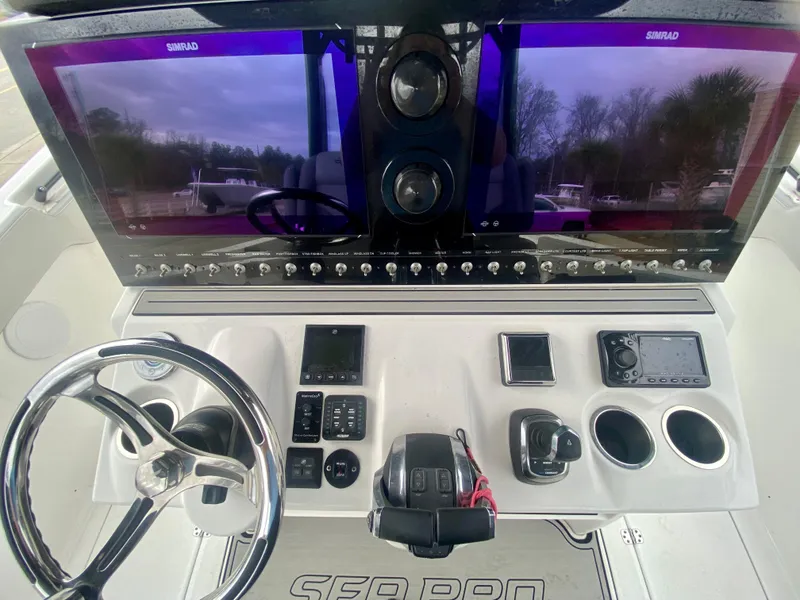 Slide: The Image of Sea Pro 320 DXL 2022 boat dashboard with dual Simrad displays and control panel. - 22