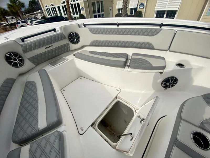 Slide: The Image of 2022 Sea Pro 320 DXL boat interior with cushioned seating and storage compartment. - 36