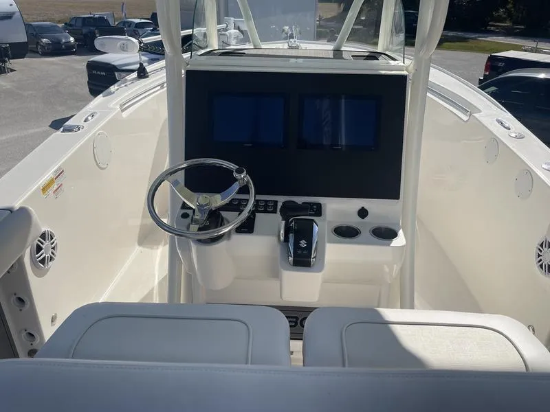 Slide: The Image of 2024 Sea Born SX239 Offshore boat cockpit with dual screens and steering wheel. - 8