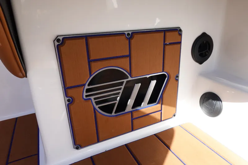 Slide: The Image of 2023 Malibu Wakesetter 24 MXZ interior detail with logo and wood paneling. - 13