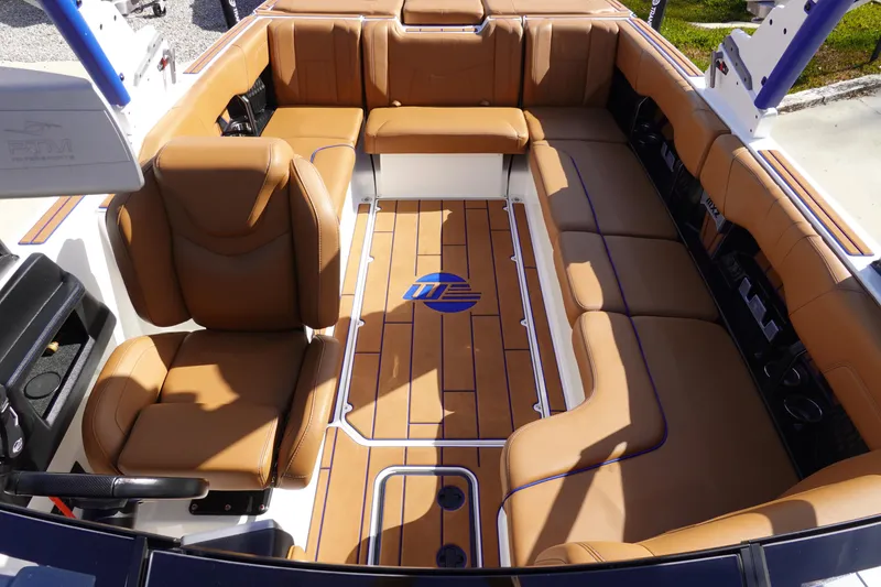 Slide: The Image of 2023 Malibu Wakesetter 24 MXZ interior with tan leather seating and wood flooring. - 18