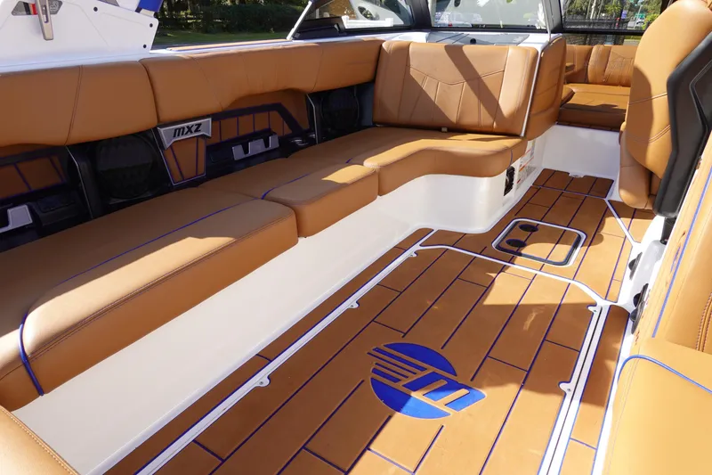 Slide: The Image of 2023 Malibu Wakesetter 24 MXZ interior with tan leather seats and custom flooring. - 21